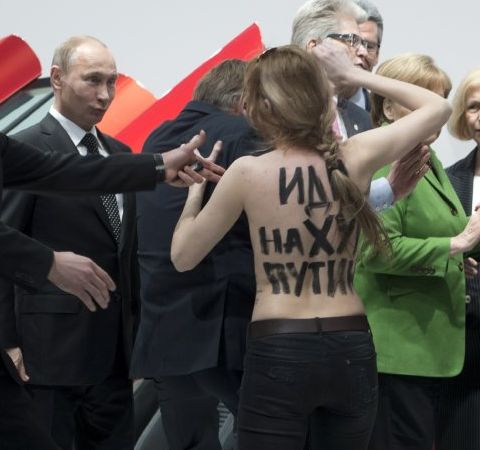 Putin grins at bare-breasted protester
